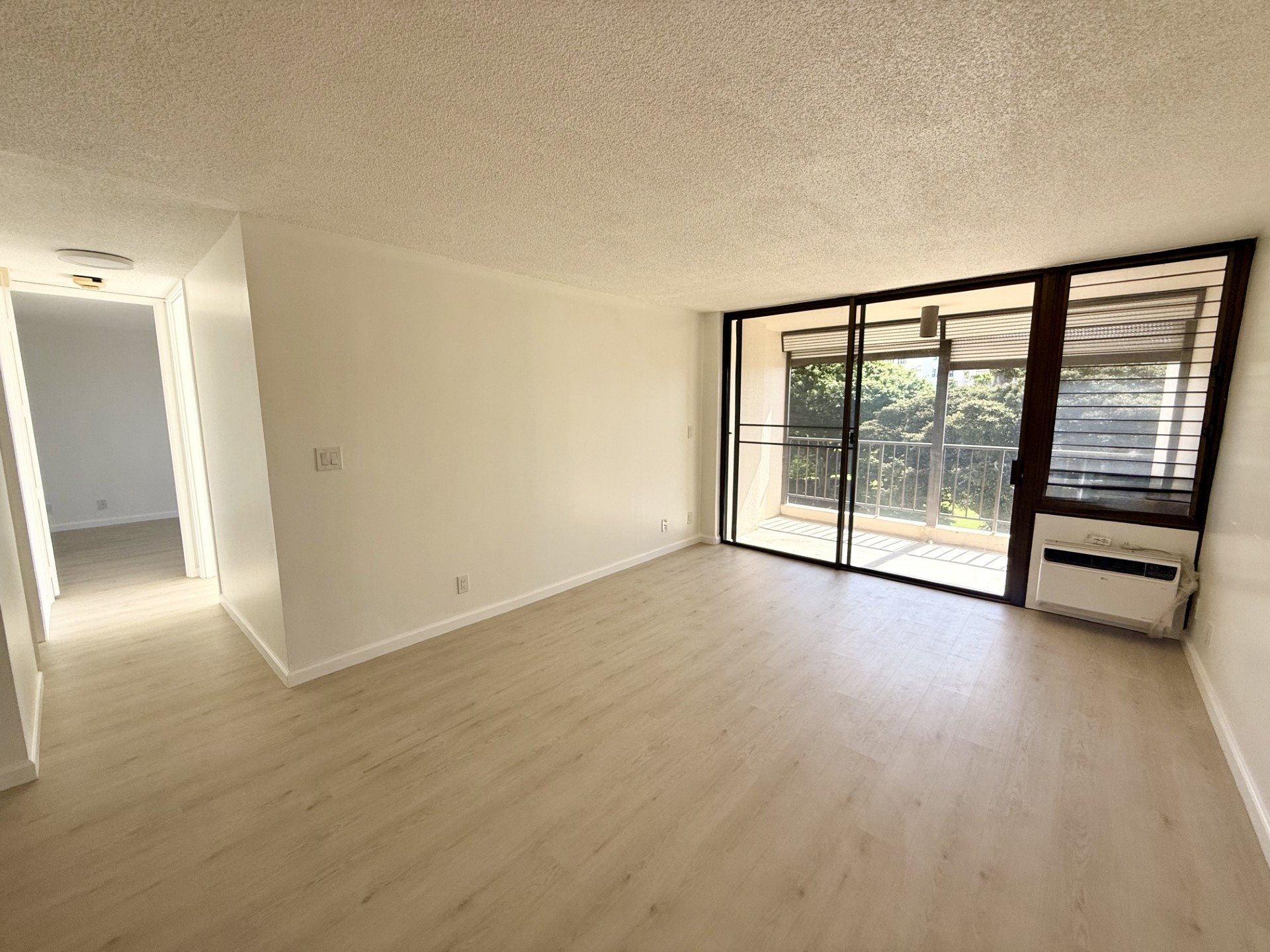 A room with a sliding glass door leading to a balcony.